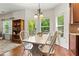 Dining room offers bright, natural light, a modern chandelier, and scenic views of the outdoors at 5655 Hedge Brook Dr, Cumming, GA 30028