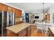 Open layout kitchen features dark wood cabinets, stainless steel appliances, and granite island at 5655 Hedge Brook Dr, Cumming, GA 30028