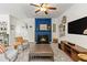 Comfortable living room featuring a blue fireplace, modern decor, and neutral gray carpet at 5655 Hedge Brook Dr, Cumming, GA 30028
