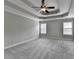 Large bedroom featuring tray ceilings with ceiling fan, neutral paint and plush carpeting at 179 Carter Rd, Auburn, GA 30011