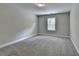 A simple bedroom with carpet, window, base molding and neutral paint at 179 Carter Rd, Auburn, GA 30011