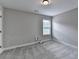 Neutral bedroom features soft carpet, a single window for natural light, and a simple ceiling light fixture at 179 Carter Rd, Auburn, GA 30011