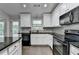 Well-lit kitchen features granite countertops, stainless steel appliances, white cabinets, and a gray tile backsplash at 179 Carter Rd, Auburn, GA 30011