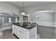 Open concept kitchen island features dark countertops, white cabinets and opens to living and dining areas at 179 Carter Rd, Auburn, GA 30011