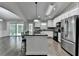Modern kitchen featuring a kitchen island, stainless steel appliances, granite countertops, and access to the living room at 179 Carter Rd, Auburn, GA 30011