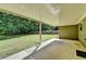 A covered patio offers views of the lush, private backyard with mature trees and partial fencing at 179 Carter Rd, Auburn, GA 30011