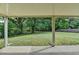 Covered patio overlooking a large, grassy backyard surrounded by lush trees and a partial fence at 179 Carter Rd, Auburn, GA 30011