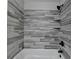 Sleek shower with modern wood-look tile and a shower head; built in shelves for added convenience at 179 Carter Rd, Auburn, GA 30011