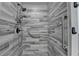 Modern walk in shower featuring stone-look tile surround and grab bars at 179 Carter Rd, Auburn, GA 30011