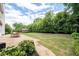 Landscaped backyard featuring a stone patio with outdoor dining and a shed at 2310 Norbury Se Cv, Smyrna, GA 30080