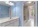 This bathroom features a wide mirror over a vanity, a shower-tub combination, and blue colored walls at 2310 Norbury Se Cv, Smyrna, GA 30080