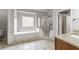 Primary bathroom featuring granite counters, shower, and soaking tub at 2310 Norbury Se Cv, Smyrna, GA 30080