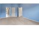 The bedroom has blue walls, carpeted floor, two entry doors, and a large window with natural light at 2310 Norbury Se Cv, Smyrna, GA 30080