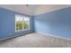 A spacious bedroom offers natural light, neutral carpet, and blue accent walls at 2310 Norbury Se Cv, Smyrna, GA 30080