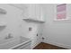 Clean laundry room with utility sink, cabinets, and hardwood floors at 2310 Norbury Se Cv, Smyrna, GA 30080