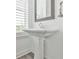 Bathroom features a pedestal sink, modern mirror, and neutral tones at 3313 Bartee Walk, Suwanee, GA 30024