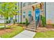 Exterior shot of townhome featuring brick steps leading to a blue front door and well-manicured landscaping at 3313 Bartee Walk, Suwanee, GA 30024
