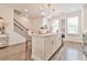Island kitchen boasts stone countertops, stainless appliances, and pendant lighting, great for entertaining guests at 3313 Bartee Walk, Suwanee, GA 30024