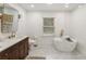 Bright bathroom featuring modern fixtures, a soaking tub, stylish vanity, and neutral tones at 410 Wilkinson Se Dr, Atlanta, GA 30317