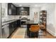 Beautiful kitchen featuring dark cabinets, stainless steel appliances, an island with barstools, and wood flooring at 410 Wilkinson Se Dr, Atlanta, GA 30317