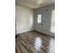 Bright living room featuring wood-look flooring, a white painted door, and bright windows at 458 Prince Of Wales, Stone Mountain, GA 30083