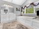 Bright bathroom features a soaking tub, vanity with storage, and natural light at 8117 Spivey Rd, Jonesboro, GA 30236