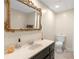 Bright bathroom features a dark vanity with countertop, decorative mirror, and tiled floors at 8117 Spivey Rd, Jonesboro, GA 30236