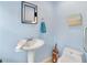Charming powder room with a pedestal sink, elegant mirror, and stylish decor at 8117 Spivey Rd, Jonesboro, GA 30236