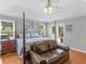 Bedroom featuring a four-poster bed, sitting area, and natural light at 8117 Spivey Rd, Jonesboro, GA 30236