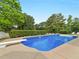 Large in-ground pool with diving board, complemented by lush landscaping and serene privacy at 8117 Spivey Rd, Jonesboro, GA 30236
