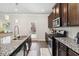 A kitchen featuring stainless appliances, dark wood cabinets, granite countertops, and access to the backyard at 109 Logan Pass Dr, Loganville, GA 30052