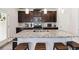 A kitchen showcasing a speckled granite island countertop with barstool seating and rich, dark wood cabinets at 109 Logan Pass Dr, Loganville, GA 30052