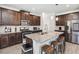 Modern kitchen features stainless appliances, a granite island with barstool seating and dark wood cabinetry at 109 Logan Pass Dr, Loganville, GA 30052