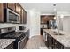 This kitchen features stainless steel appliances, dark wood cabinets, and granite countertops on an island at 109 Logan Pass Dr, Loganville, GA 30052