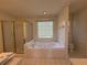 Bright bathroom featuring a soaking tub, glass shower, and tiled floor at 1301 Winesap Se Ct, Conyers, GA 30013