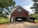 Exterior shot of attached garage featuring red brick and white trim, with a car parked inside at 1301 Winesap Se Ct, Conyers, GA 30013