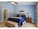 Cozy bedroom with blue walls, ceiling fan, carpet floors, and a door leading to the bathroom at 1605 Pavillion Ridge Se Dr, Smyrna, GA 30080