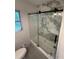 Updated bathroom featuring glass door, bathtub and marble tile surround at 1640 Fairburn Sw Rd, Atlanta, GA 30331