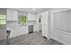 Modern kitchen featuring white cabinets, stainless steel appliances, and updated gray wood-look flooring at 1640 Fairburn Sw Rd, Atlanta, GA 30331