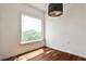 Bright room featuring hardwood floors, a modern light fixture, and a large window showcasing treetop views at 275 13Th Ne St # 605, Atlanta, GA 30309