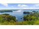 Expansive aerial view of a serene lake surrounded by lush green forests and scattered homes with boat docks at 3030 Heatherstone Dr, Cumming, GA 30041