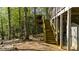 Exterior stairs provide access to the upper level of the house surrounded by a lush, wooded landscape at 3030 Heatherstone Dr, Cumming, GA 30041