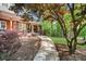 Welcoming brick home with a covered porch and a stone pathway, set amidst mature trees and landscaping at 3030 Heatherstone Dr, Cumming, GA 30041