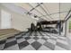 Spacious garage with checkered floors and a car lift system for storing multiple vehicles at 3030 Heatherstone Dr, Cumming, GA 30041