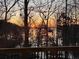 Sunset lake view from a deck surrounded by bare trees in the off season with string lights at 3030 Heatherstone Dr, Cumming, GA 30041