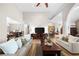 Open-concept living room boasts vaulted ceilings, hardwood floors, and seamless flow to dining and kitchen areas at 3030 Heatherstone Dr, Cumming, GA 30041