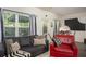 Cozy living room with a dark sofa, patterned pillows, and large windows providing ample natural light at 1296 Taylor Way, Stone Mountain, GA 30083