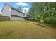 Large, grassy backyard with mature trees and a wooden fence at 173 Kingswood Dr, Ellenwood, GA 30294