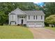 Charming home featuring a two-car garage, complemented by a well-maintained lawn and bay window at 173 Kingswood Dr, Ellenwood, GA 30294