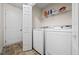 Functional laundry room with modern washer and dryer units and shelving at 173 Kingswood Dr, Ellenwood, GA 30294